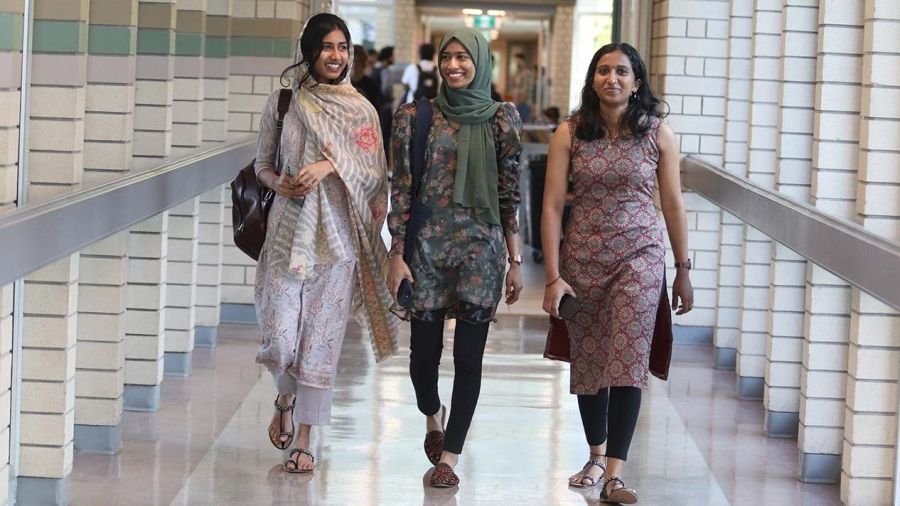 Three international students walking down hallway on the Castlegar Campus